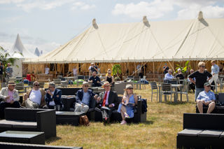 First Class Lounge guests on outdoor sofas at RIAT25 with marquee in the background.