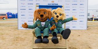 Dash and Ava the RIAT mascots sitting on the RIAT chair at RIAT25.