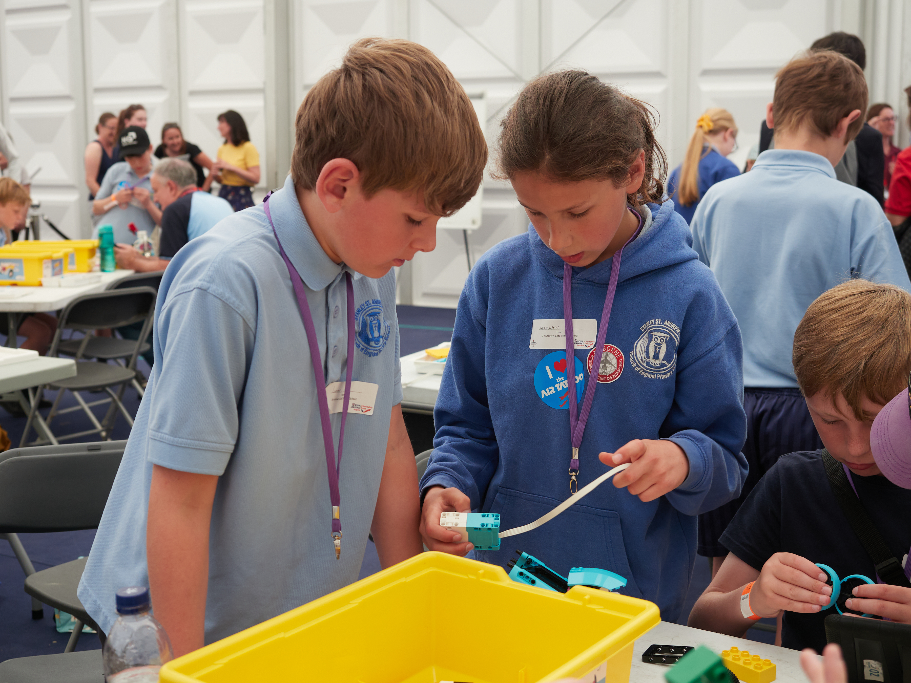 Children engaging in STEM activities with tape and lego at RIAT24