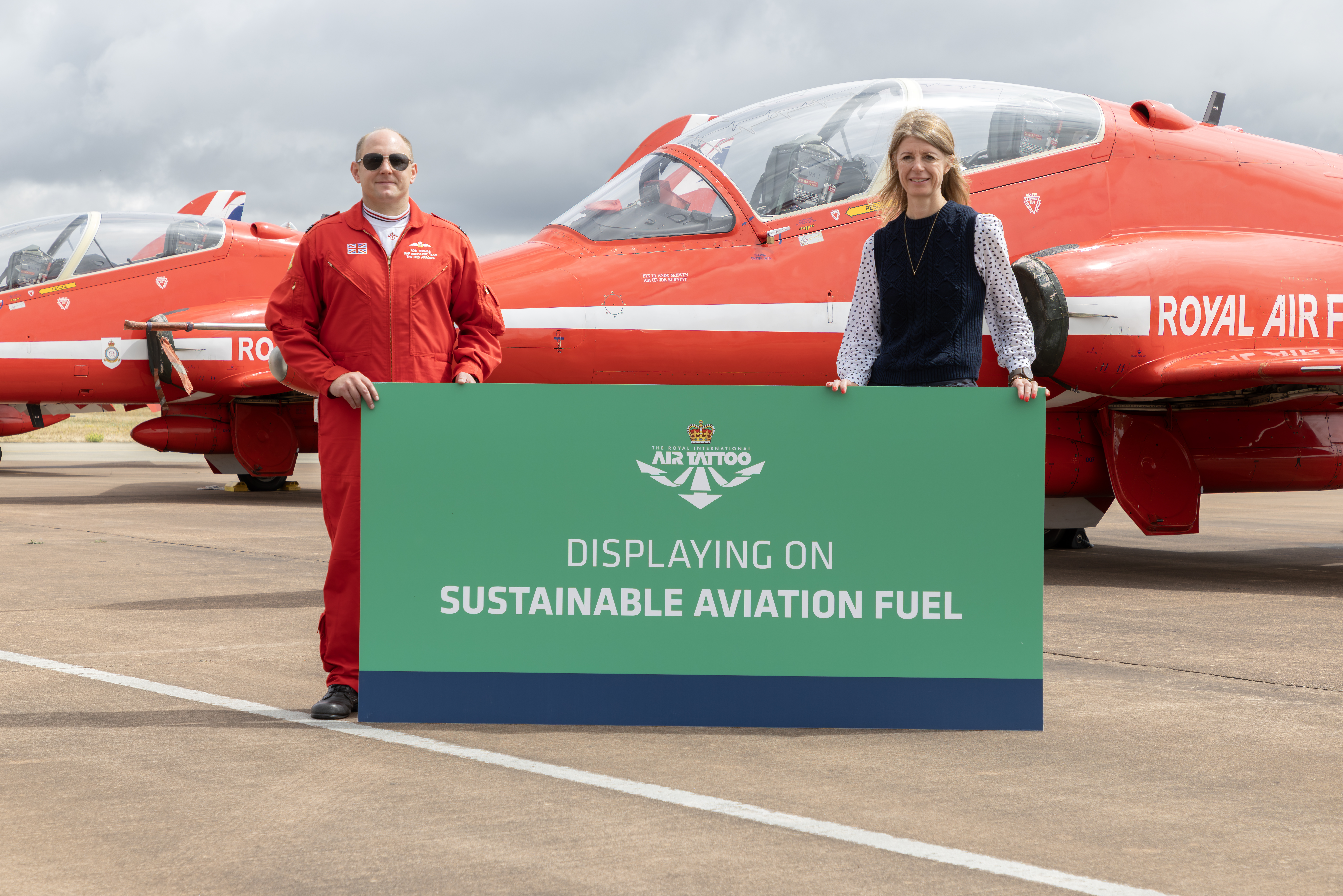 Kate McKinley, People & Sustainability Director with Red Arrow holding Displaying with Sustainable Aviation Fuel sign.
