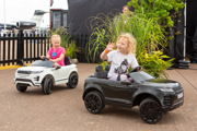 Two young girls driving model Range Rovers at RIAT24.