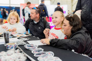 Family in Techno Zone in front of an exhibit with stickers at RIAT25.